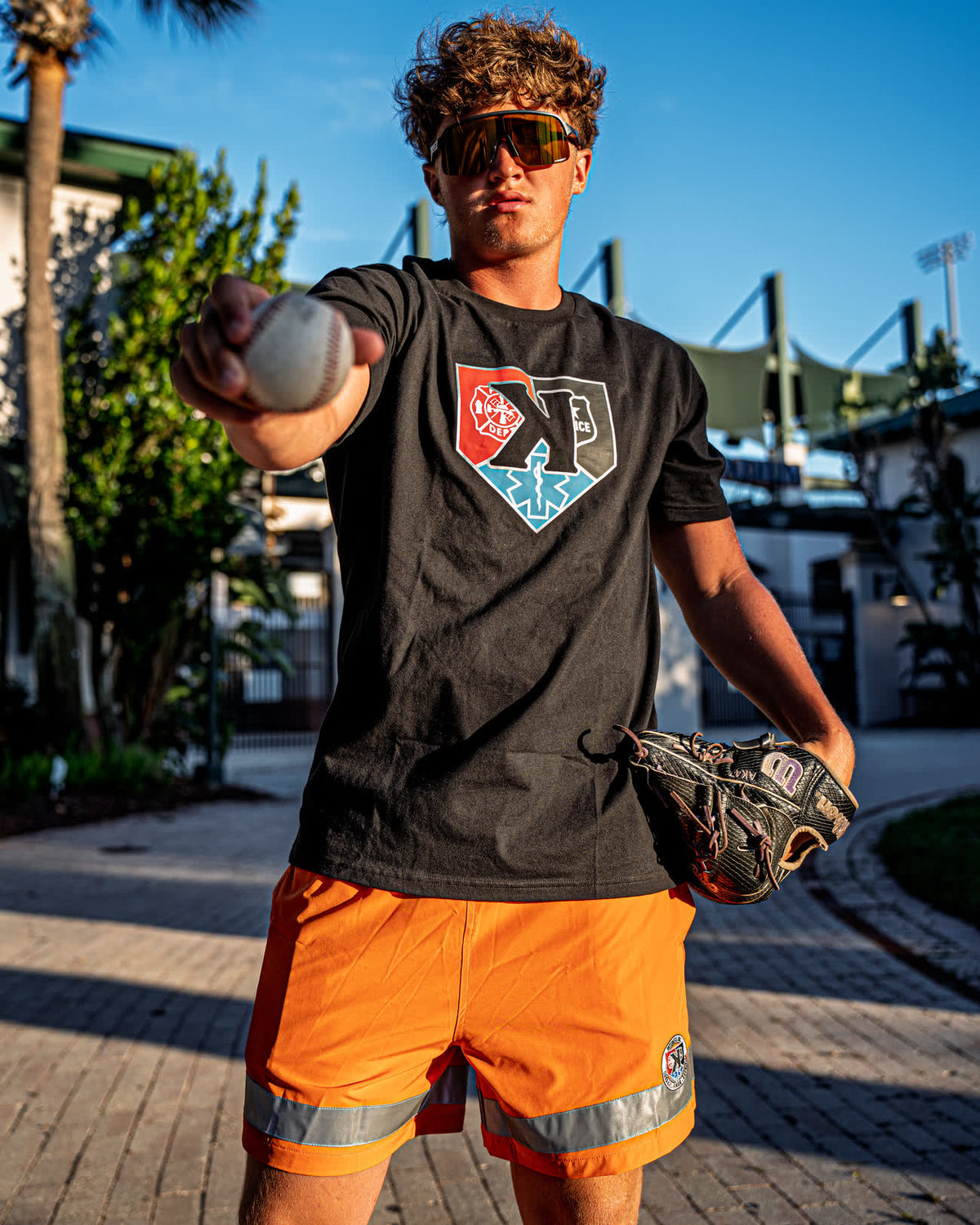 Pitcher holding a baseball out in the First Responders Tee and Safety Orange First Responders Shorts - Pitchers Only