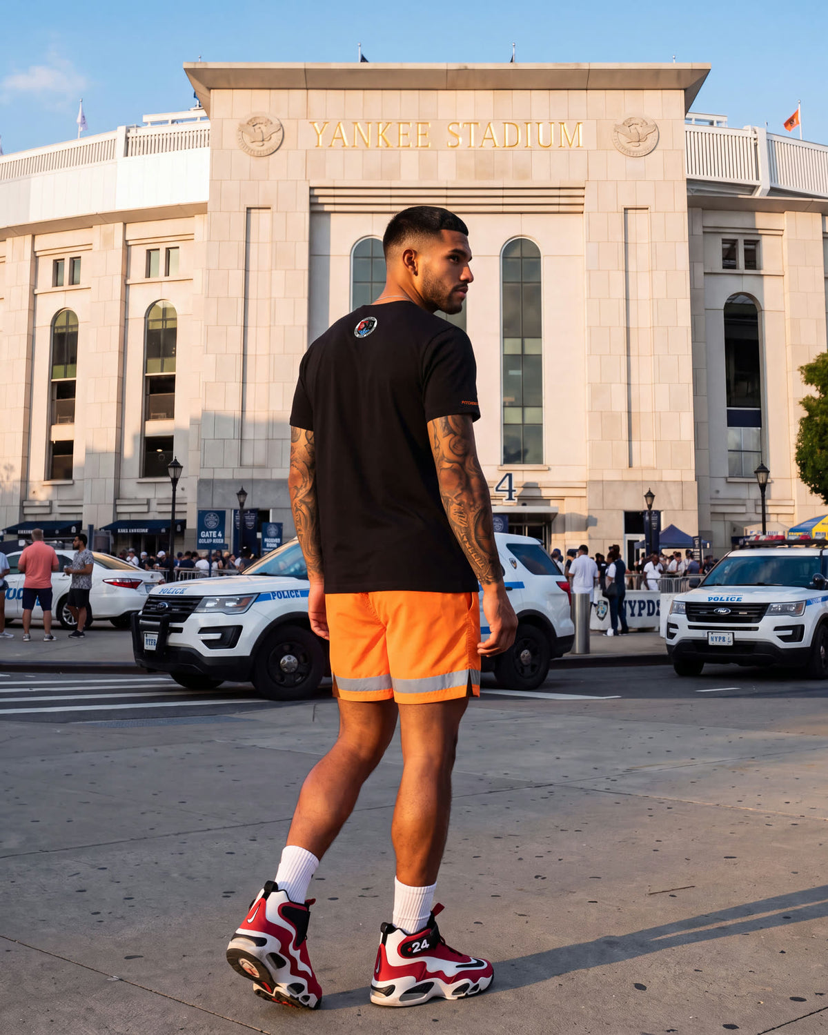 Back view of the First Responders Tee and Shorts outside Yankee Stadium, NYPD cruisers behind