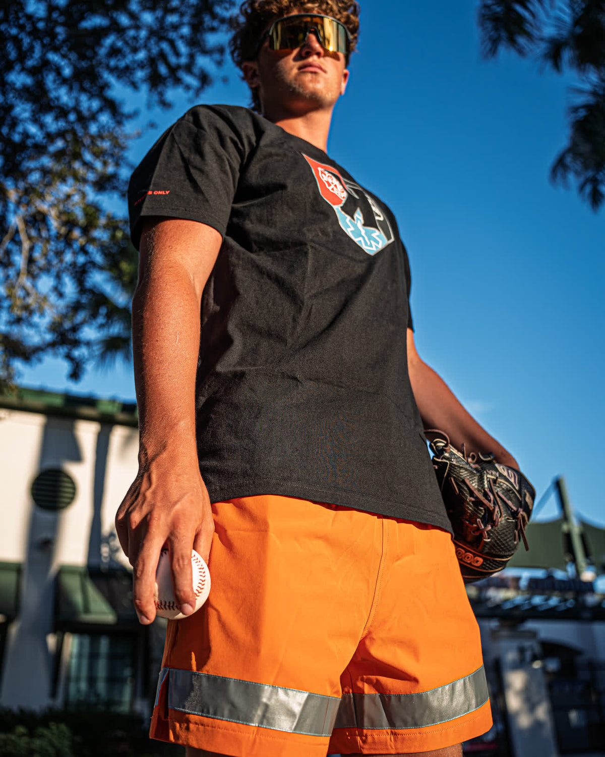 Pitcher in the First Responders Tee and Safety Orange First Responders Shorts holding a baseball and glove - Pitchers Only