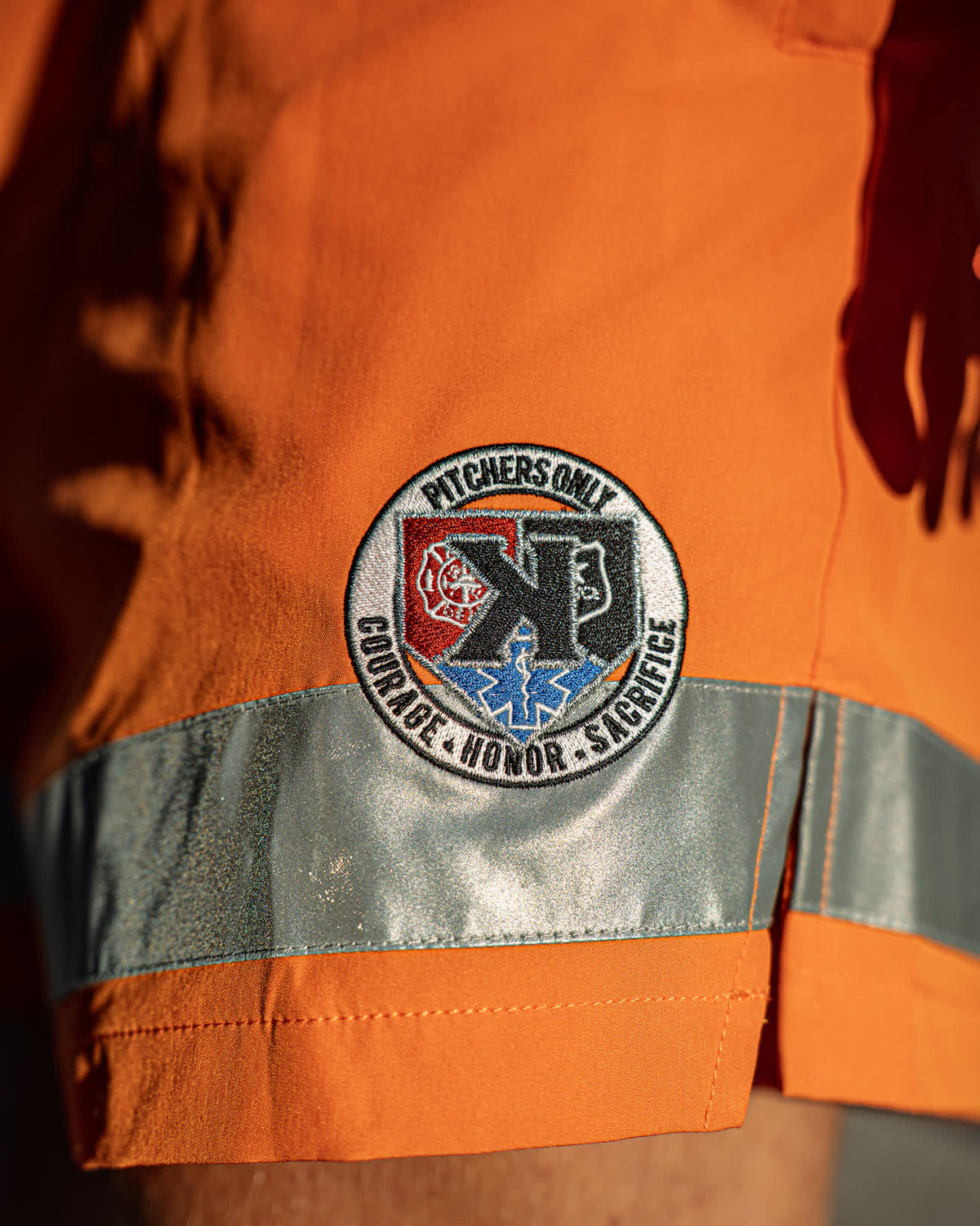 Close-up of the First Responders Shorts embroidered Courage, Honor, Sacrifice patch and 3M reflective trim - Pitchers Only