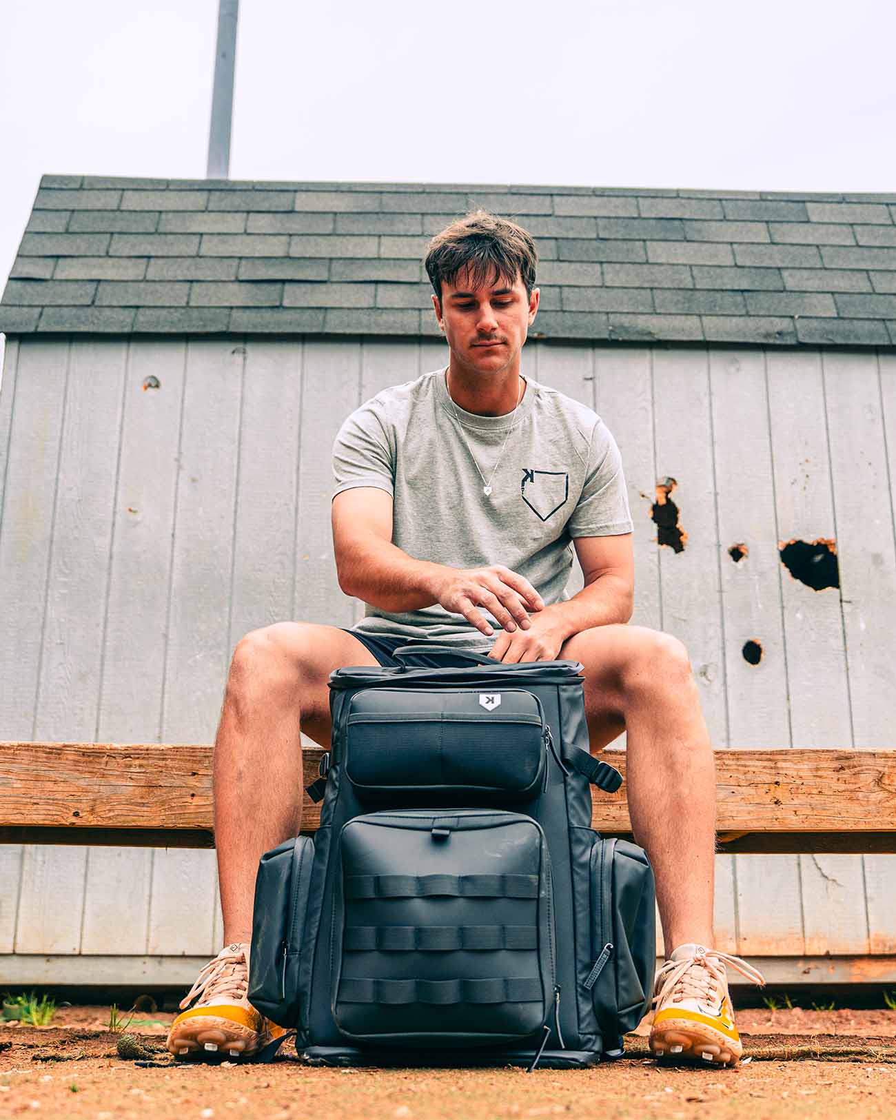 Baseball player sitting with Pitchers Only Black Shove Day Bag.