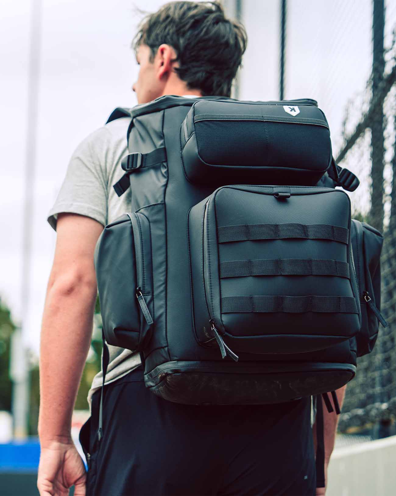 Baseball player walking with Pitchers Only Black Shove Day Bag on his back.