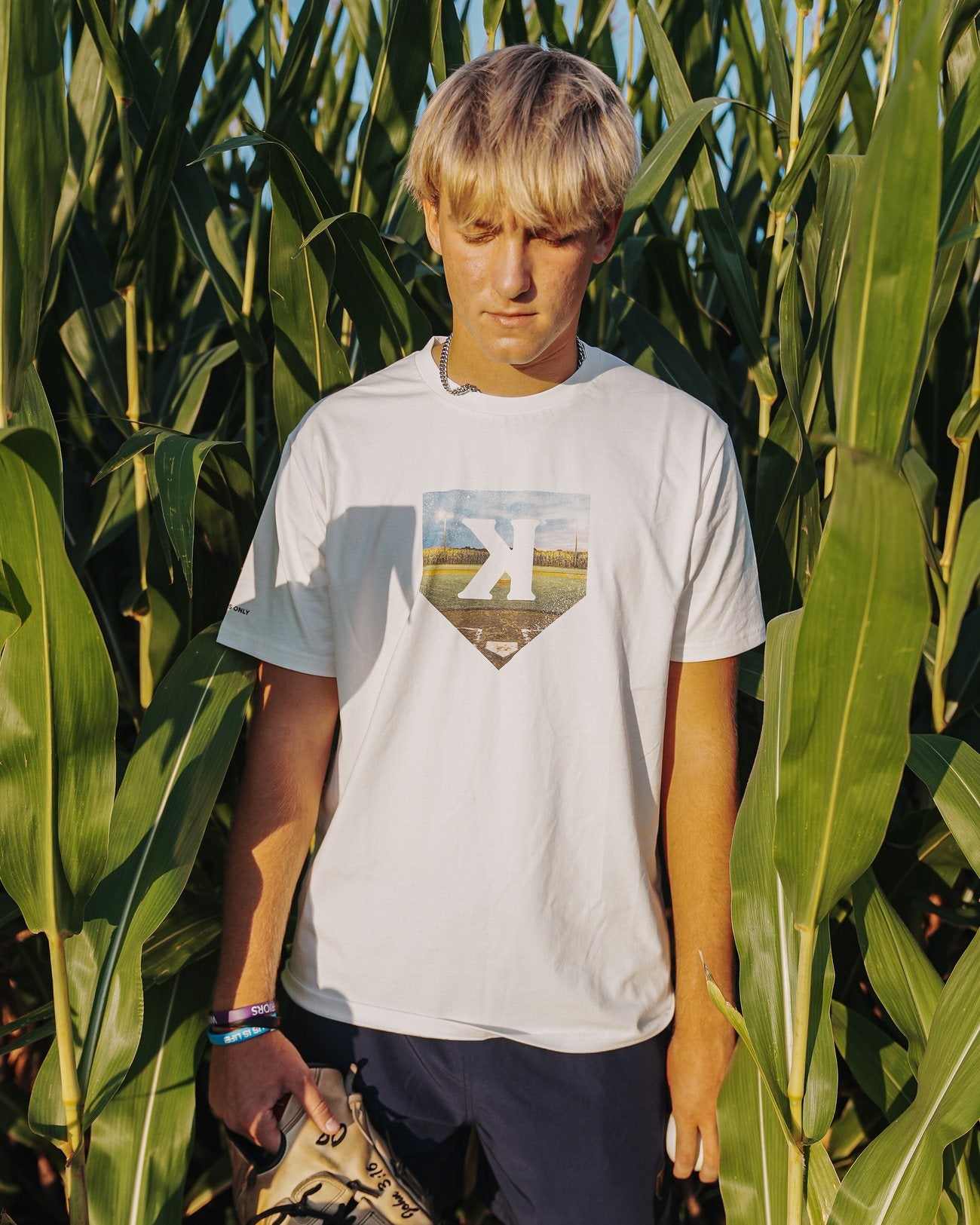 Mound of Dreams Tee worn in a cornfield, front print visible