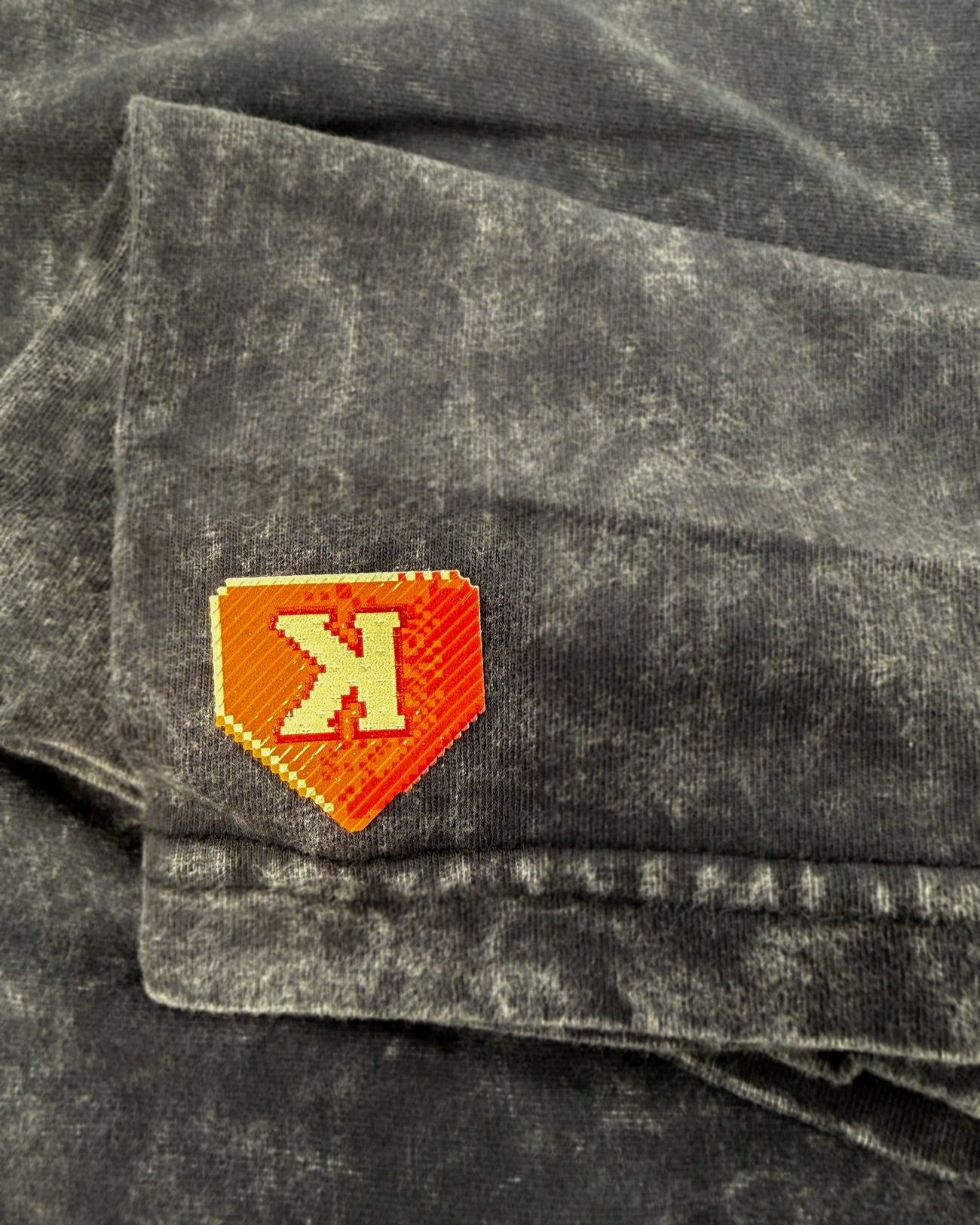 The Show Tee right sleeve, raised 8-bit K plate