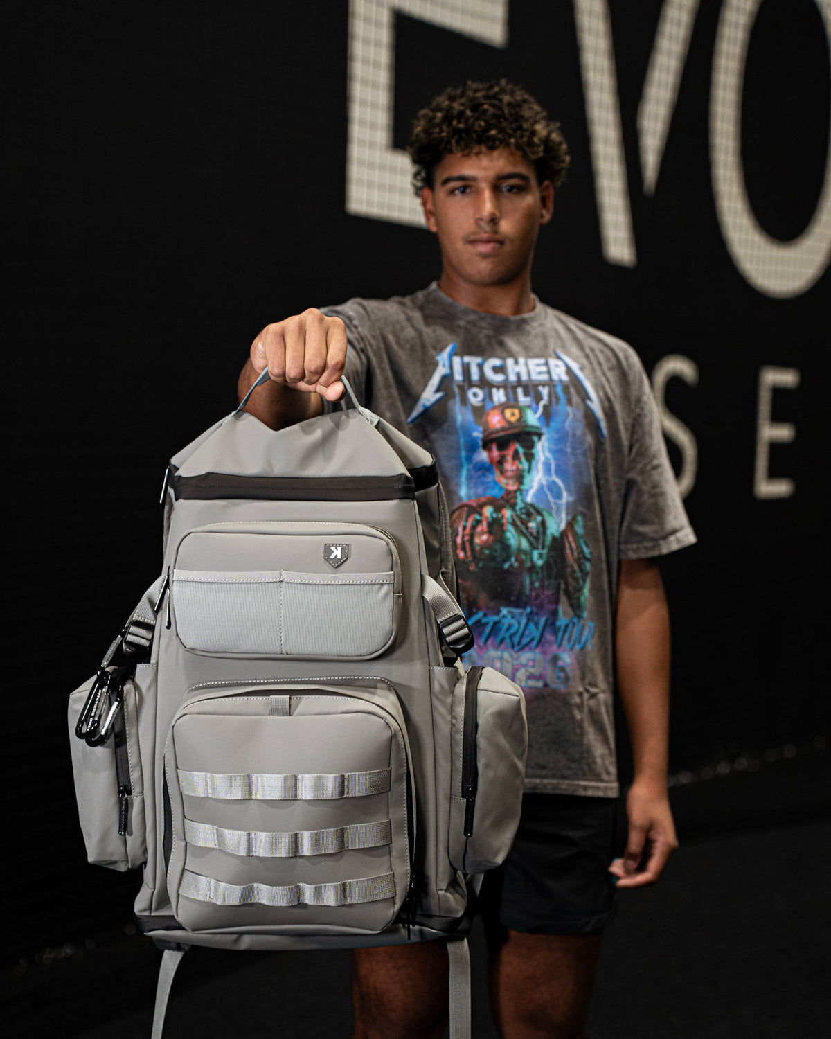 Baseball player holding the Pitchers Only Wolf Gray Shove Day Bag by the handle.
