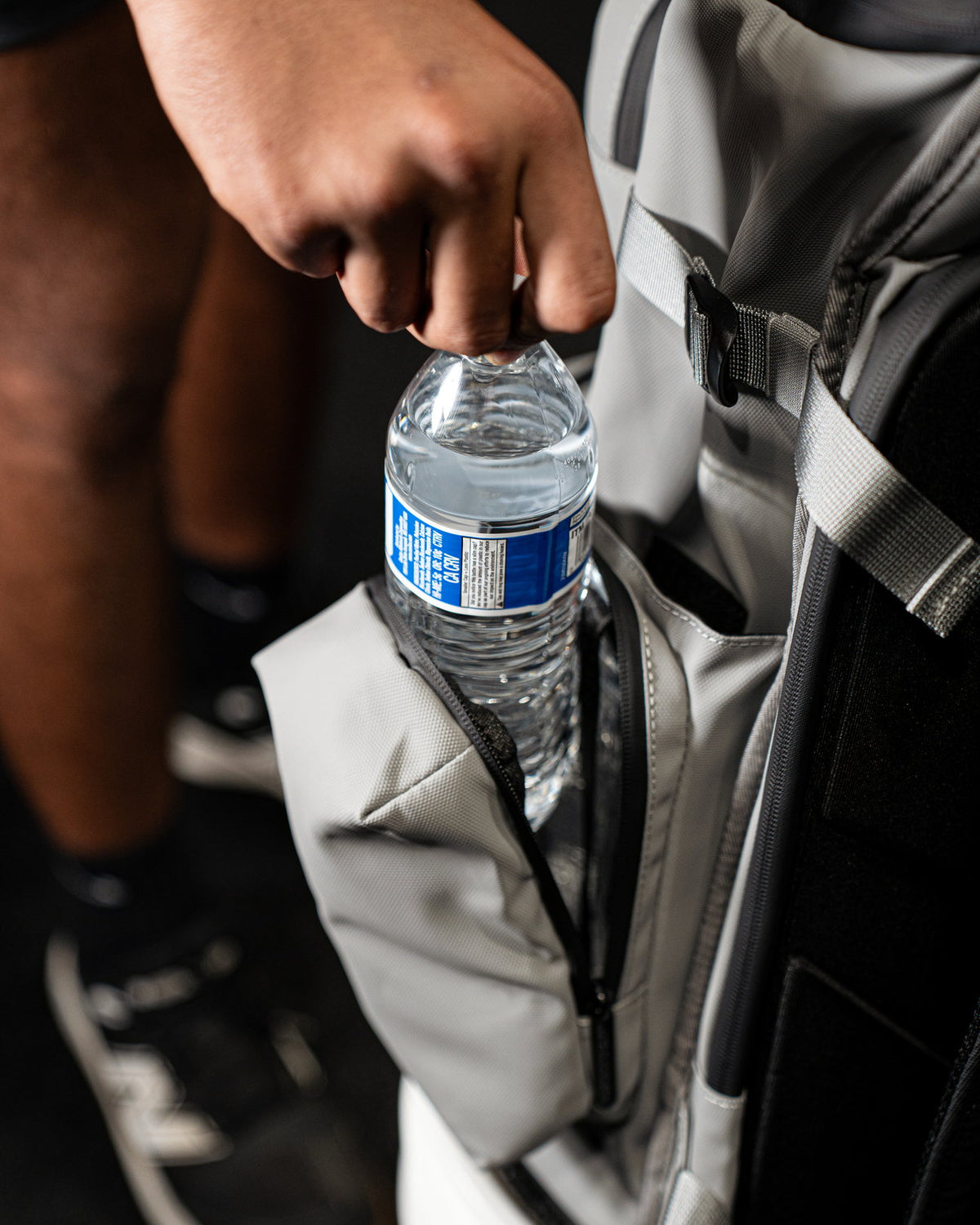 Water bottle sliding into the side pocket of the Pitchers Only Wolf Gray Shove Day Bag.