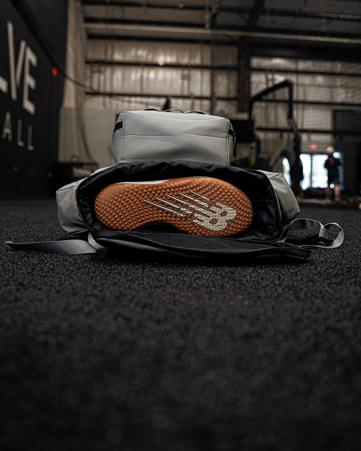 Pitchers Only Wolf Gray Shove Day Bag open on the turf with a shoe packed inside.